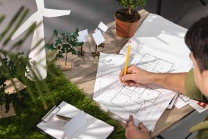 high-angle-man-working-eco-friendly-wind-power-project-with-paper-plans